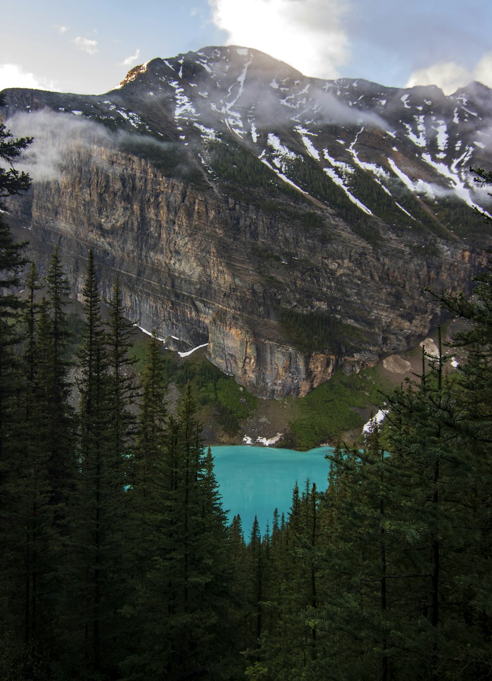 a mountain with a lake surrounded by trees