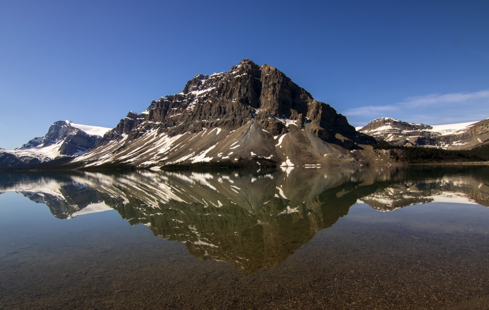 a mountain is reflected in the still water of a lake