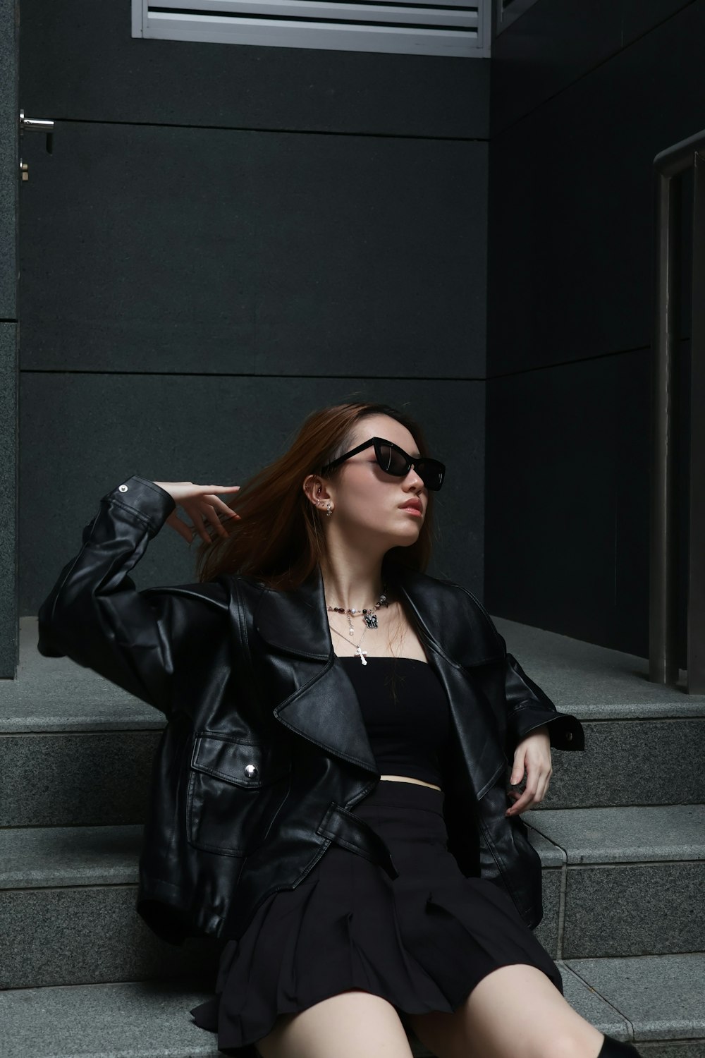 a woman in a black dress sitting on some steps