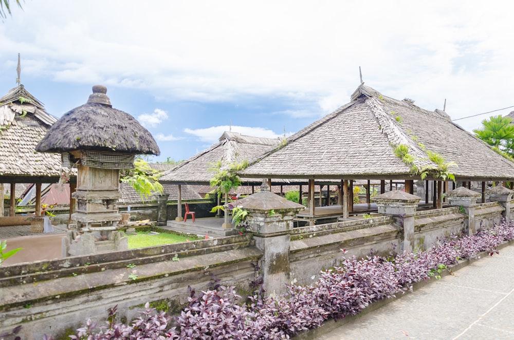 a row of wooden buildings sitting next to a lush green field