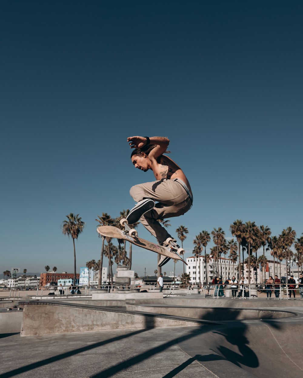 Un hombre volando por el aire mientras monta una patineta