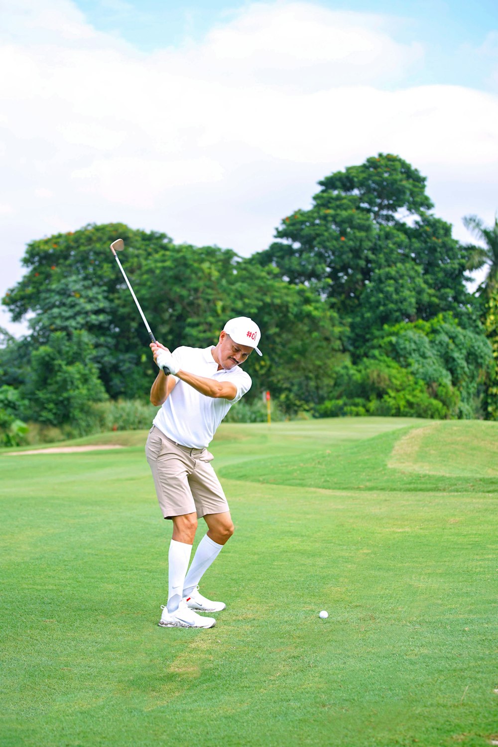 a man swinging a golf club on a golf course