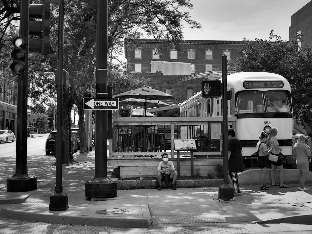 a black and white photo of a bus and some people