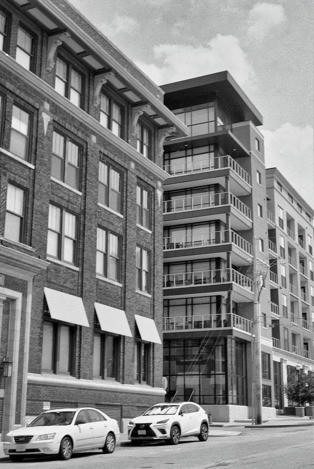 a black and white photo of cars parked in front of a building