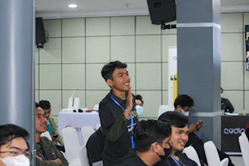 A student presenting research findings at a seminar with engaged audience members.