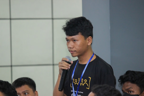 Lina María Garrido confidently addressing the crowd with a microphone.