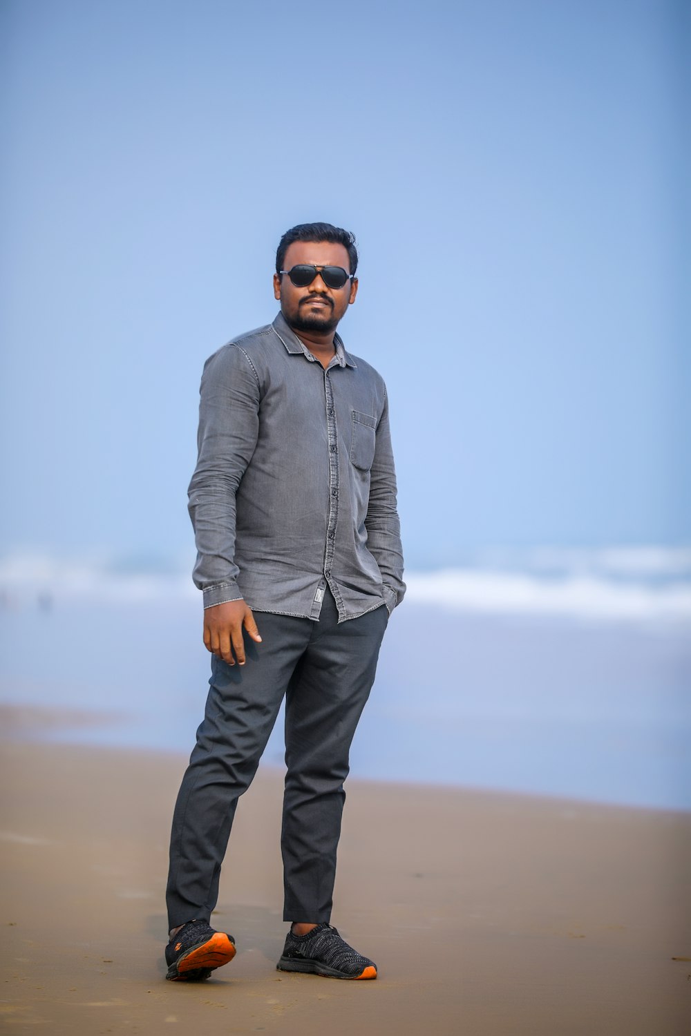 a man standing on a beach next to the ocean