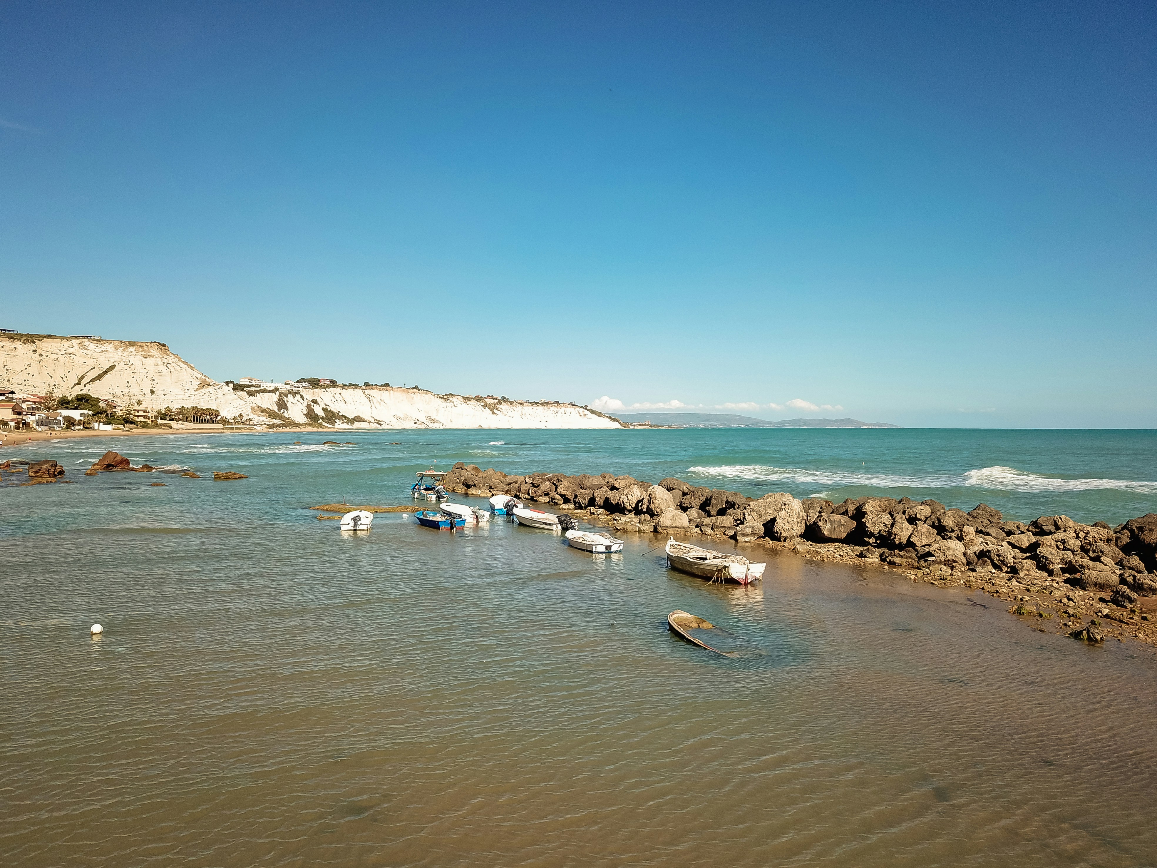 a group of boats floating on top of a body of water