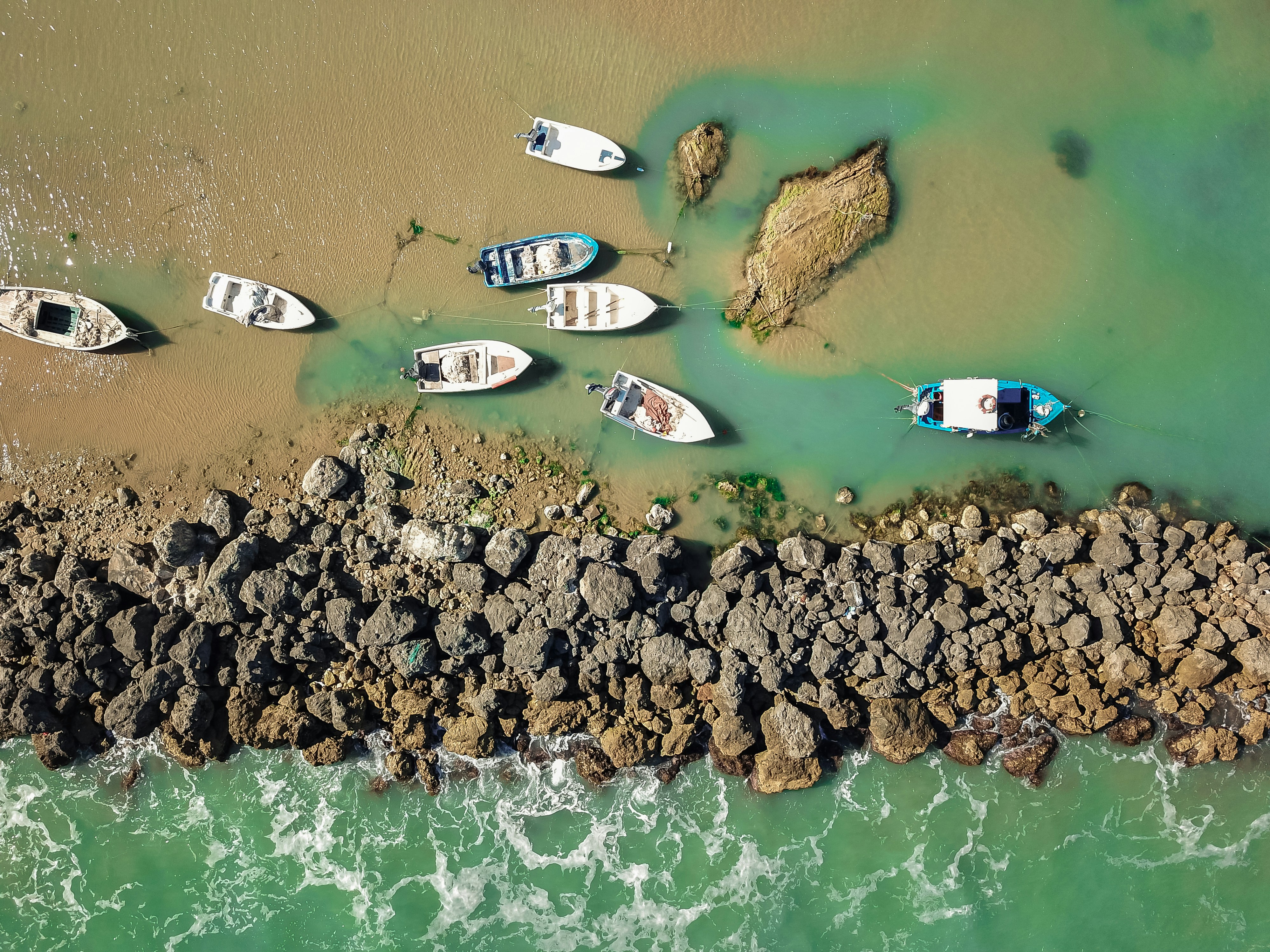 a group of boats sitting on top of a rocky shore