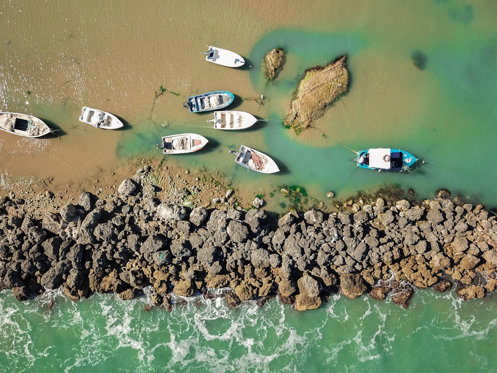 a group of boats sitting on top of a rocky shore
