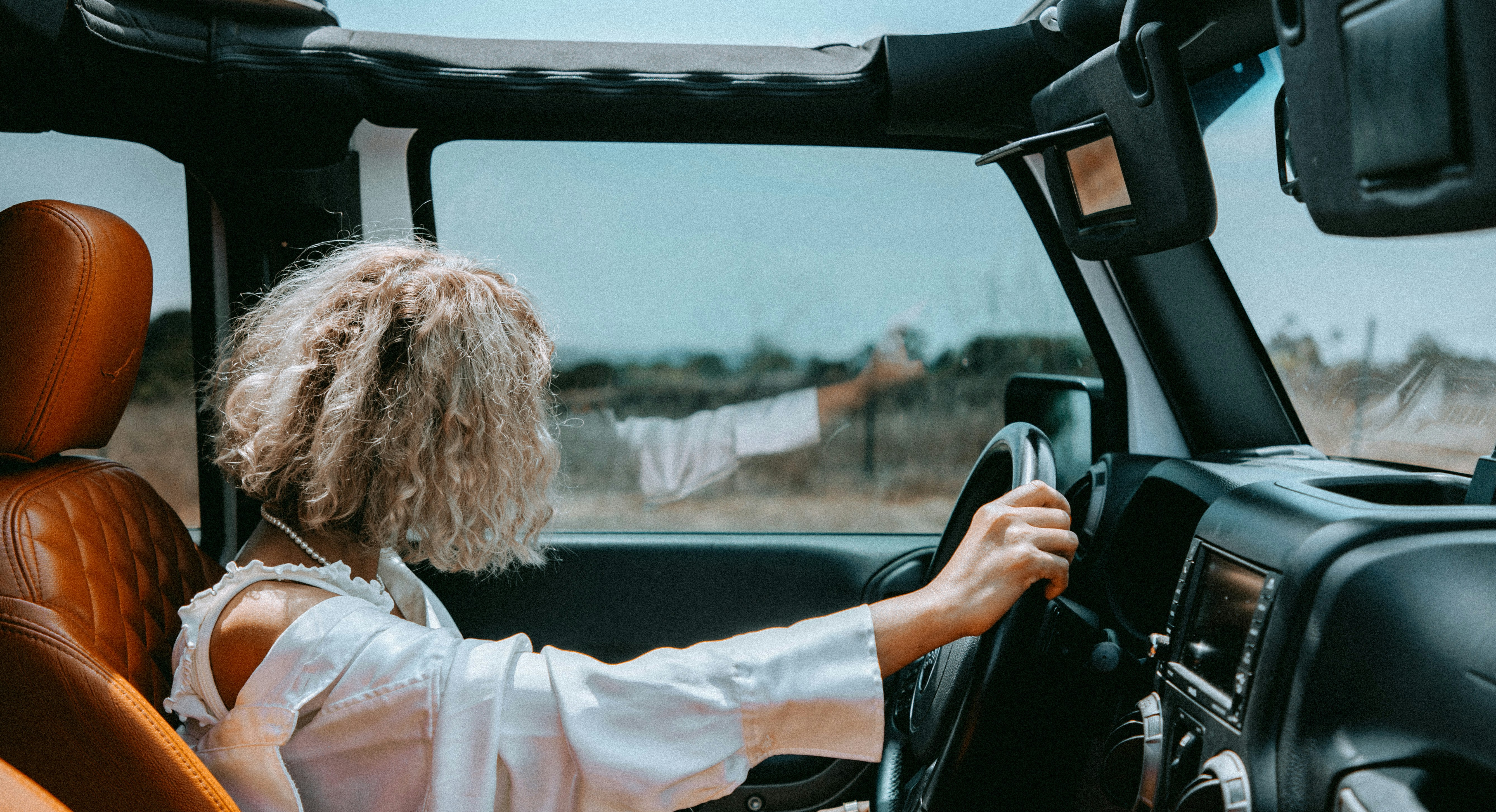 a woman driving a truck on a rural road