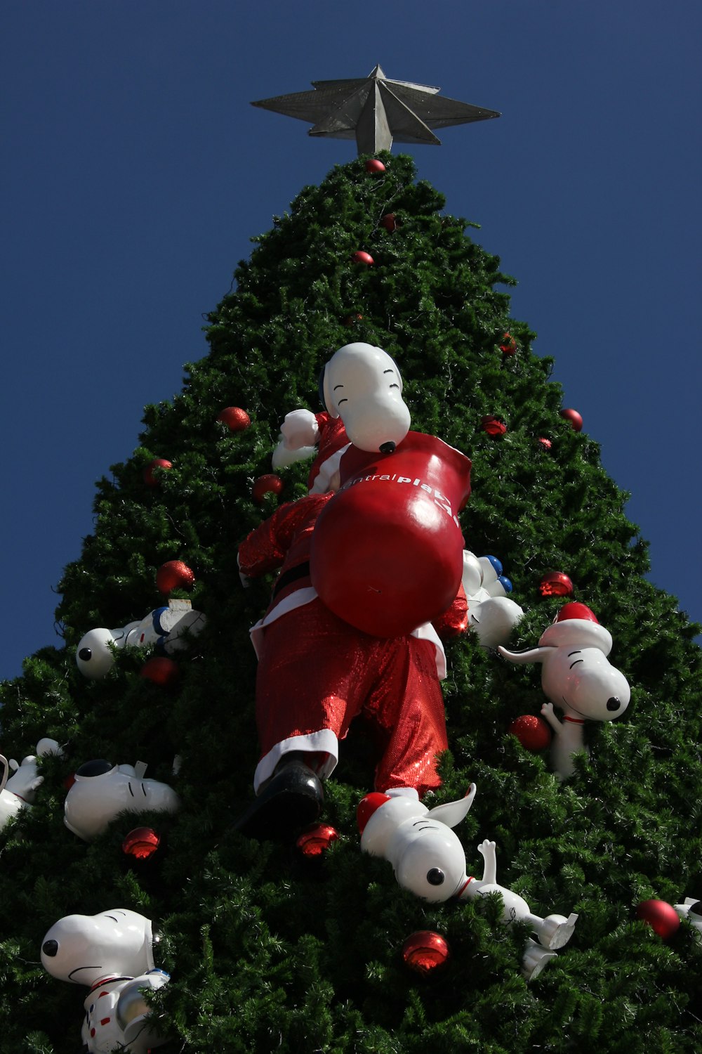 a large christmas tree with a giant inflatable santa clause