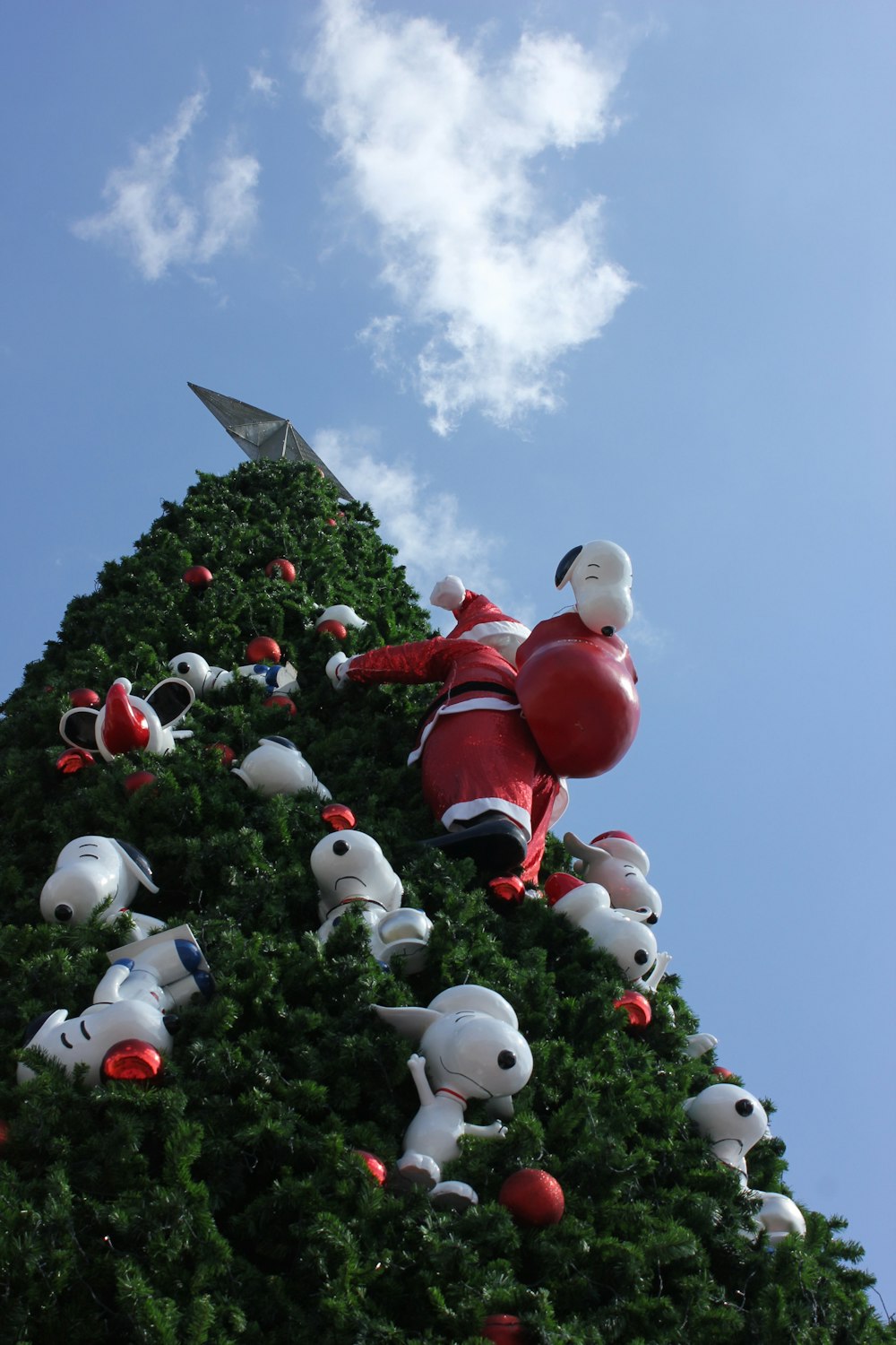uma árvore de Natal com uma cláusula de Papai Noel subindo nela