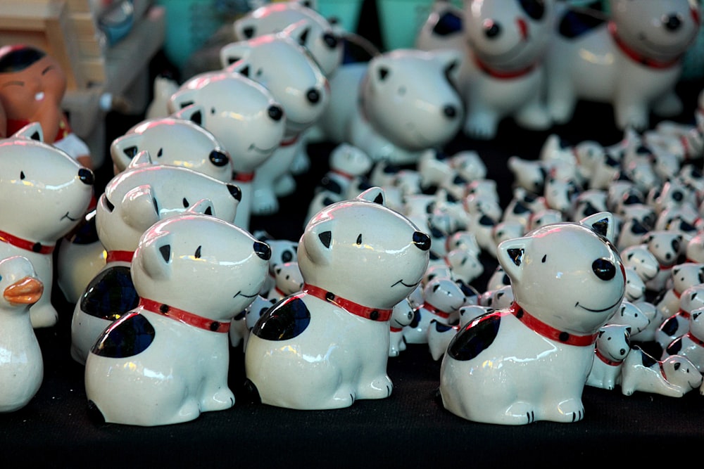 Un gruppo di cani di ceramica bianca con collari rossi