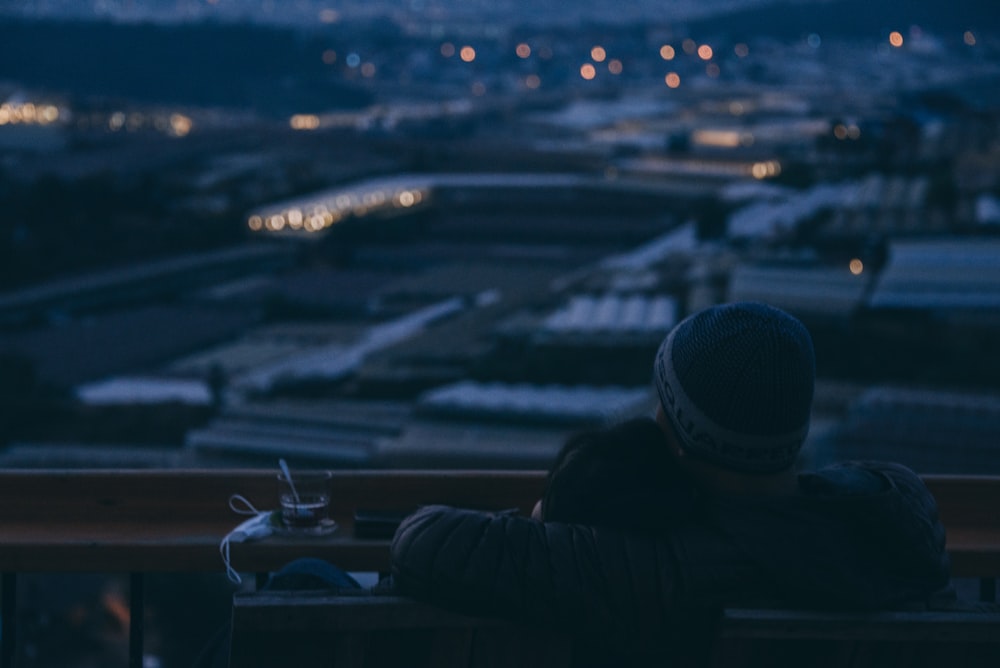 a person sitting on a bench looking out over a city