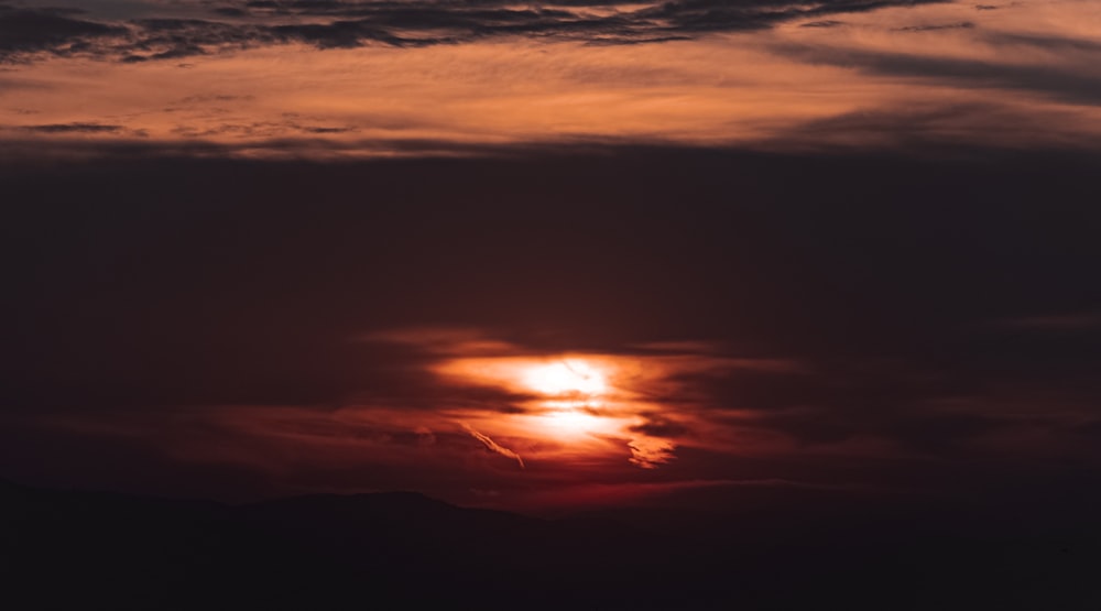 the sun is setting over a mountain range