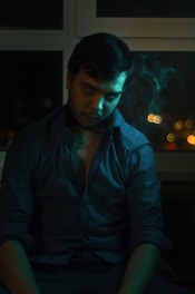 A moody, cinematic portrait of Sahil Chraya in a dark, elegant office space, surrounded by marketing strategy notes and screens.