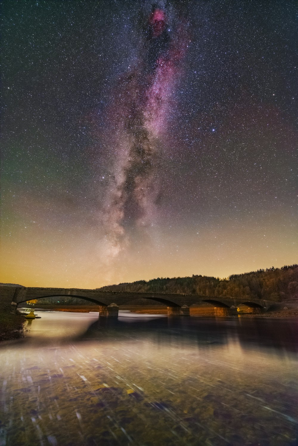 Eine Brücke über einen Fluss unter einem Nachthimmel