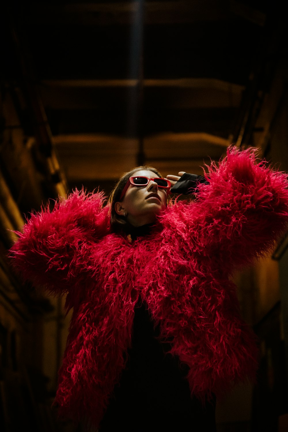a woman wearing a red jacket and sunglasses