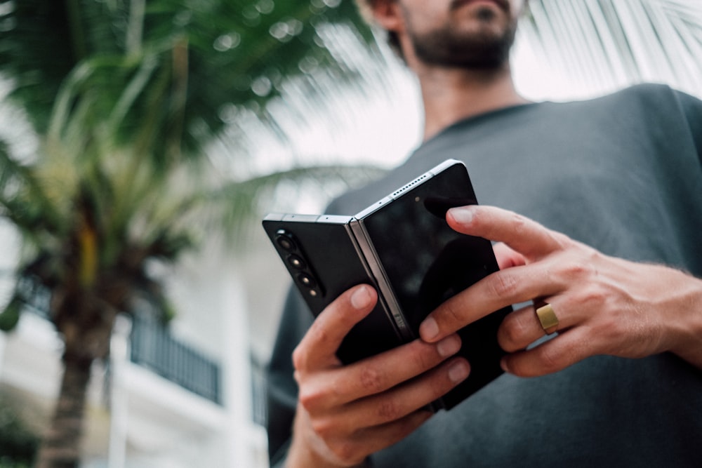 Un hombre sosteniendo un teléfono inteligente en sus manos