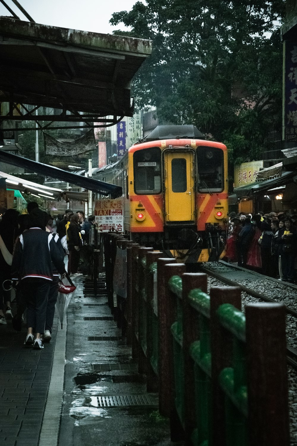 a yellow and red train traveling through a train station