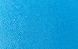 Blue surface covered with small water droplets creating a textured appearance.