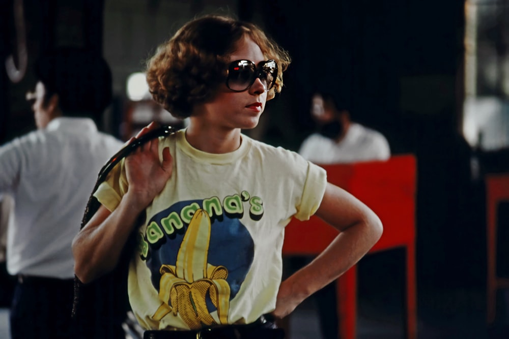 a woman wearing a banana t - shirt and sunglasses