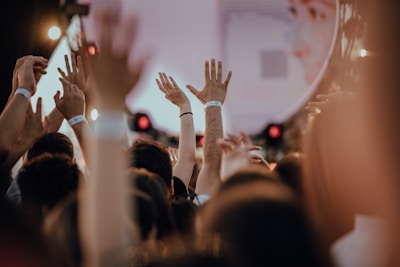 Close-up of hands in the air, glowing wristbands lighting up the night.