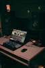 A cozy home studio setup with a microphone, headphones, and a laptop