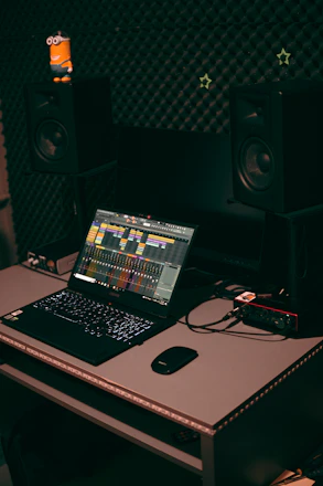 A cozy home studio setup with a nylon-string acoustic guitar, microphone, and audio interface ready for recording.