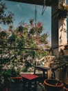 A serene outdoor balcony with seating and greenery.