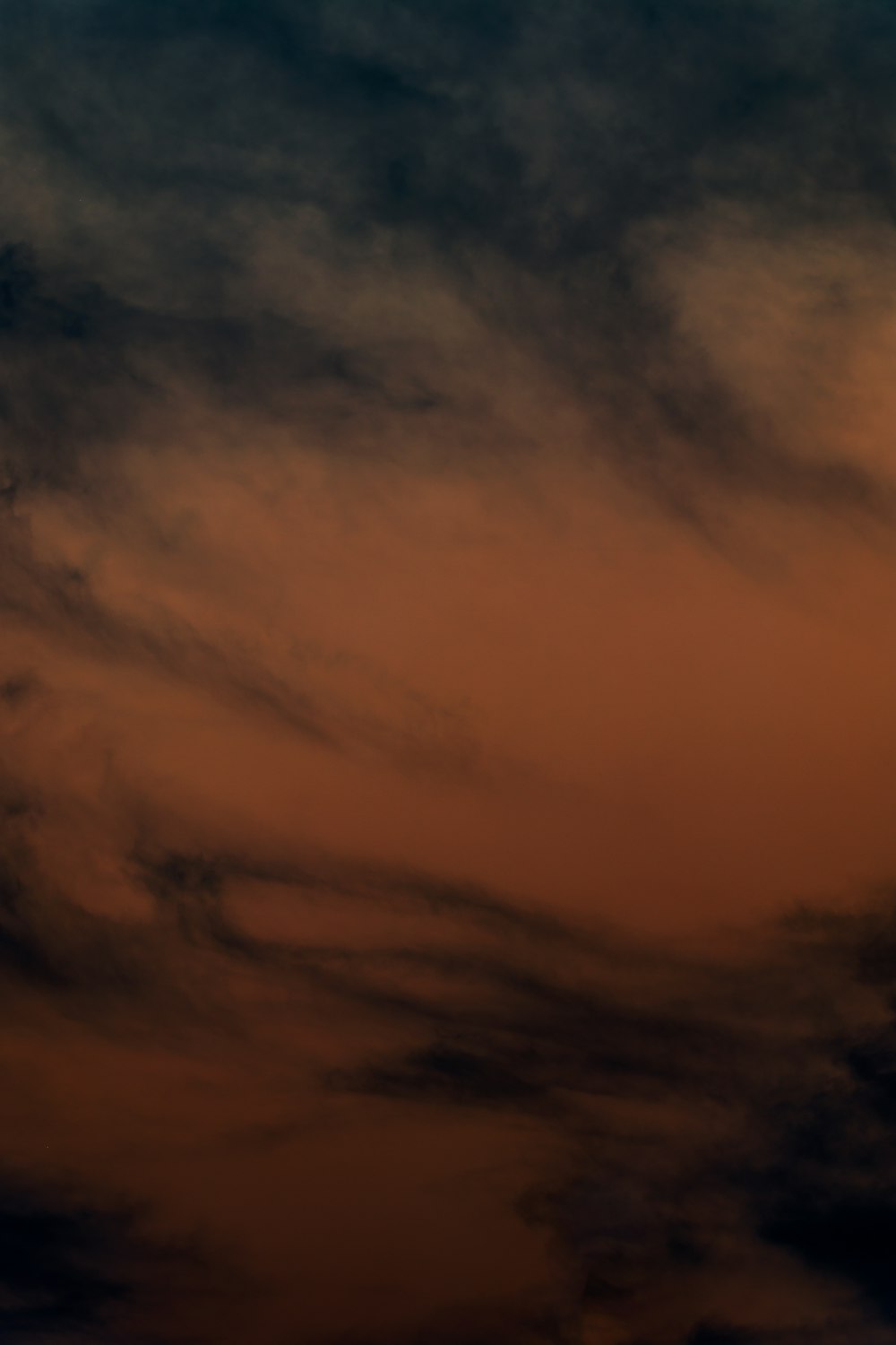 a plane flying in the sky at sunset