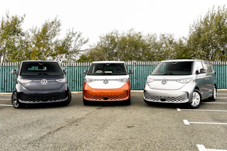 three electric vehicles parked in a parking lot