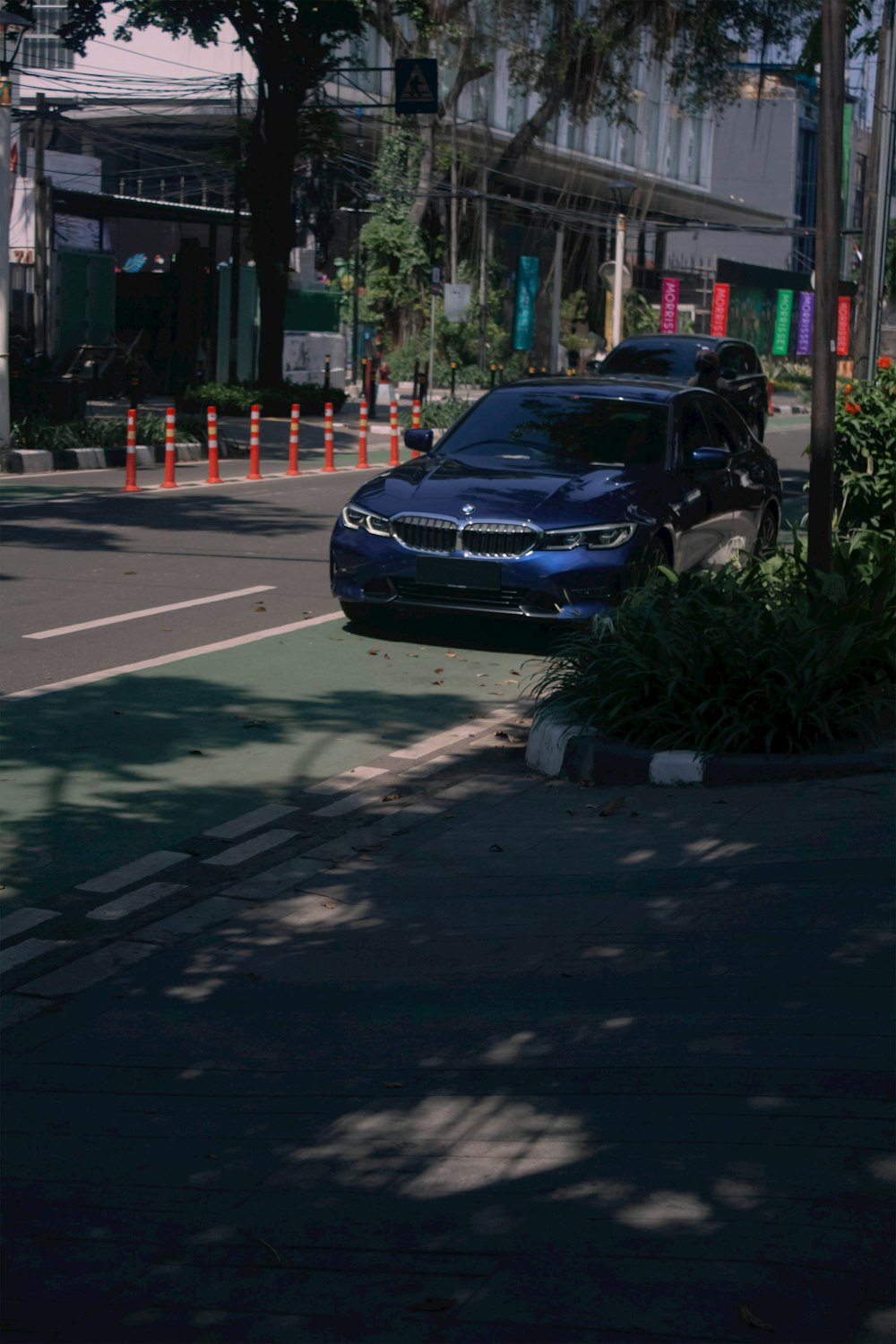 a blue car parked on the side of a road