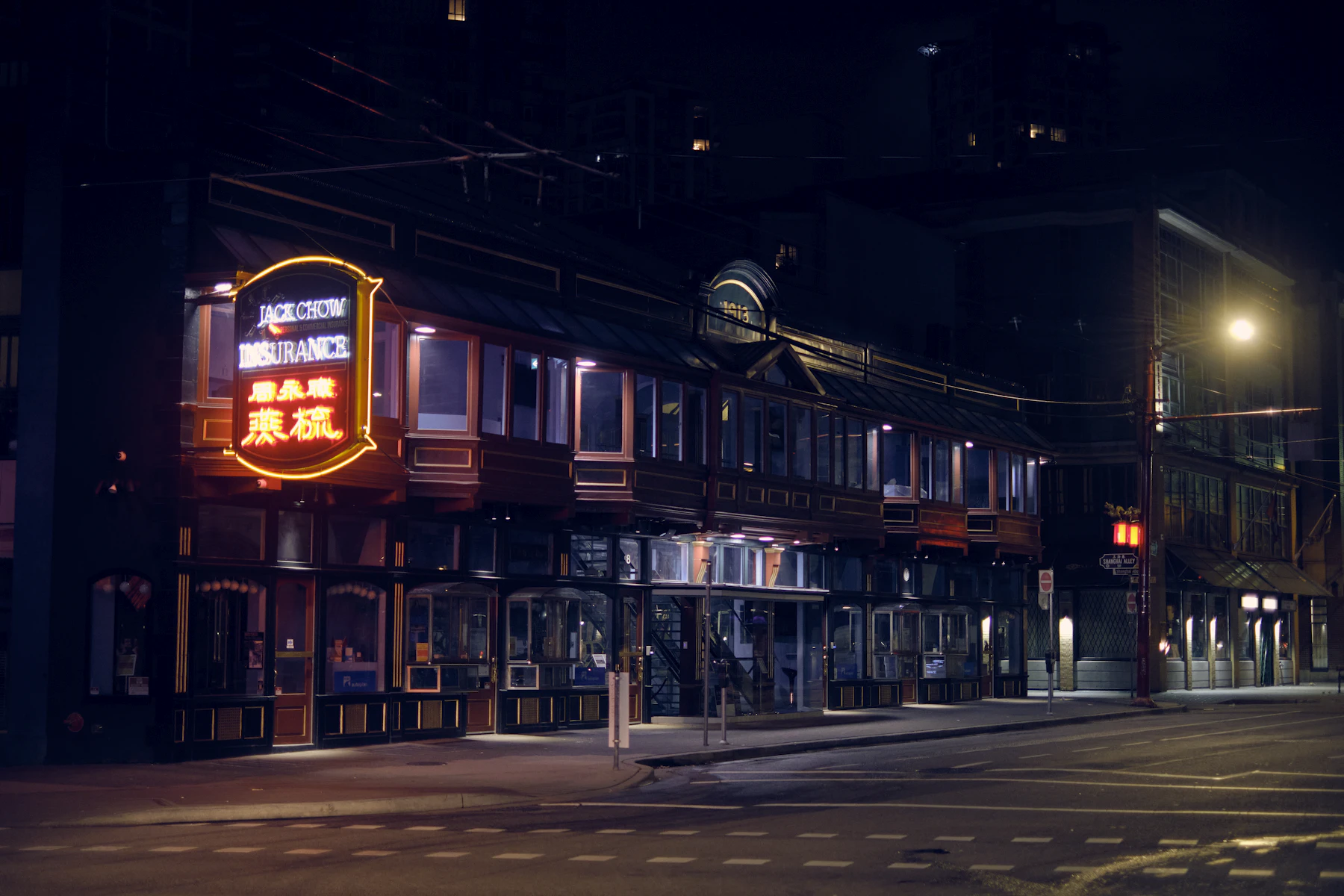 A lit shopfront sign on a dark street