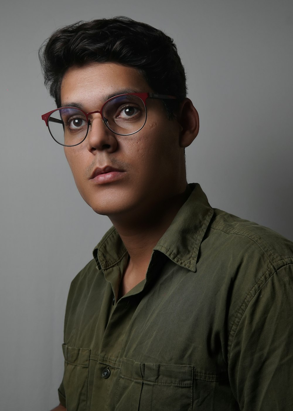 Un hombre con gafas y una camisa verde