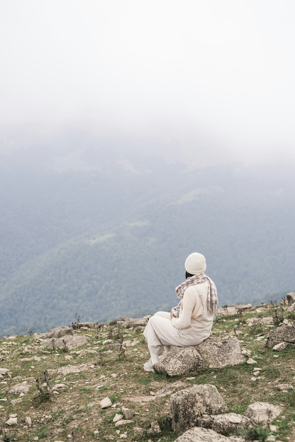 a person sitting on top of a rocky hill