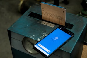 Close-up of a mobile phone showing the time and location stamp during employee check-in