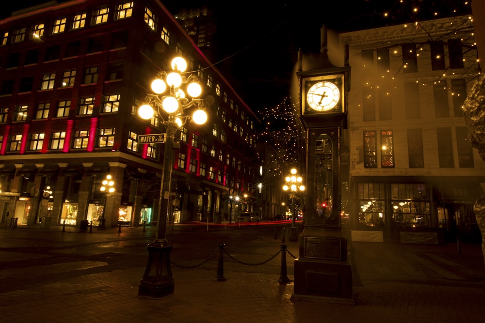 a clock tower in the middle of a city at night