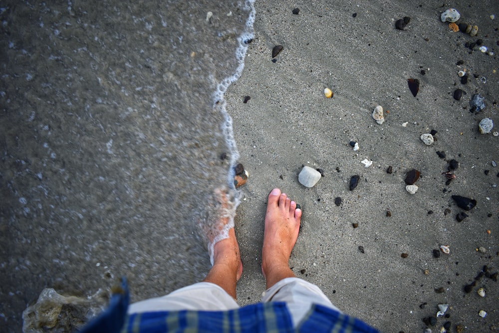 a person standing on a beach next to the ocean