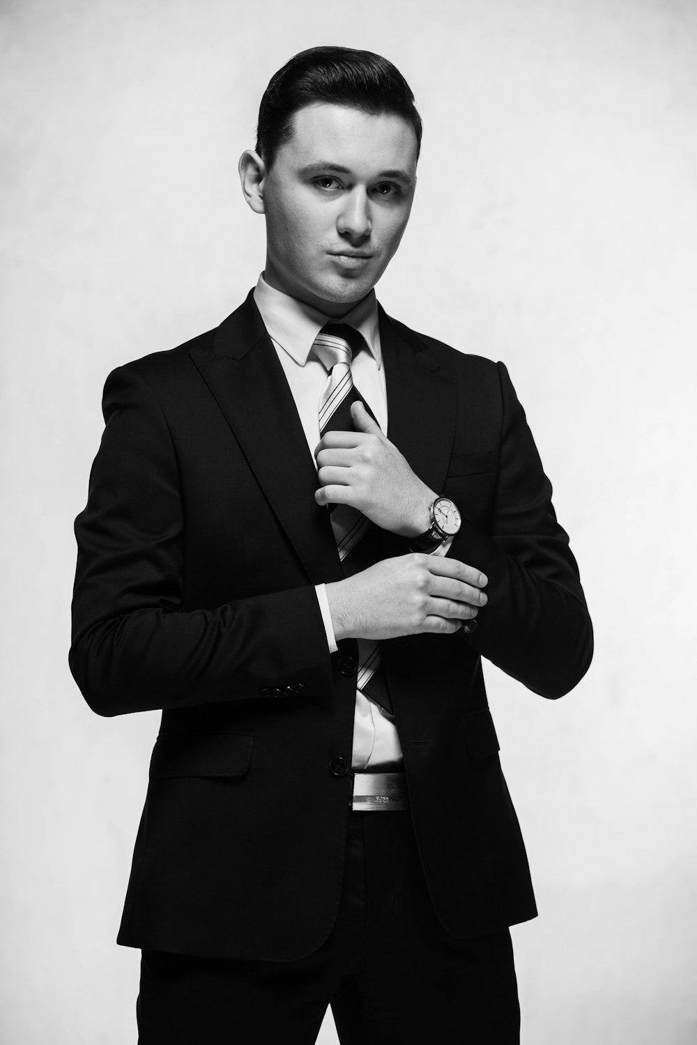 a man in a suit adjusting his tie