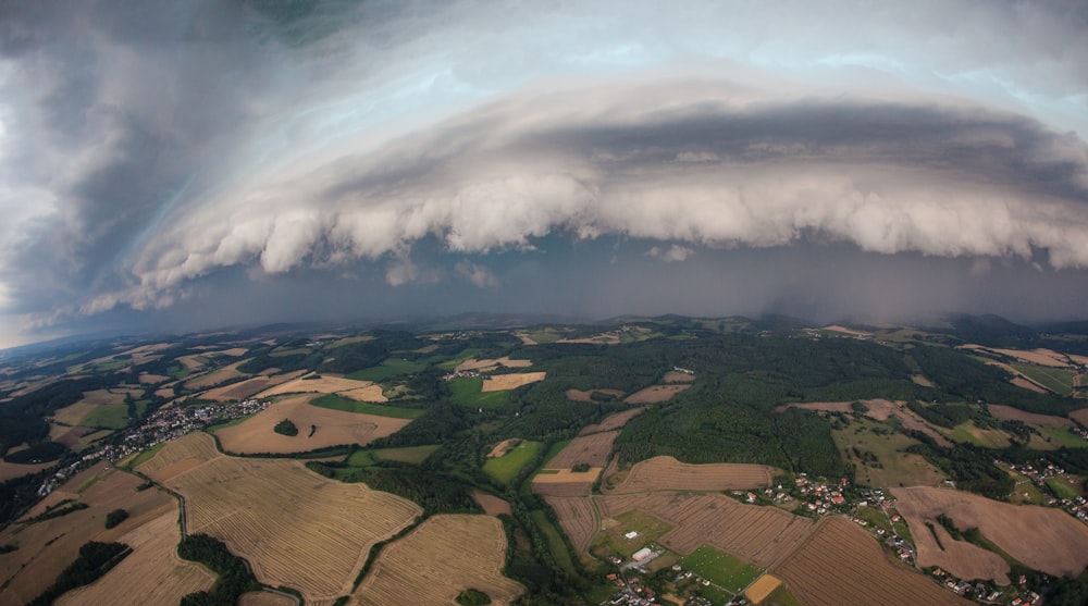 a large storm cloud looms over a rural area