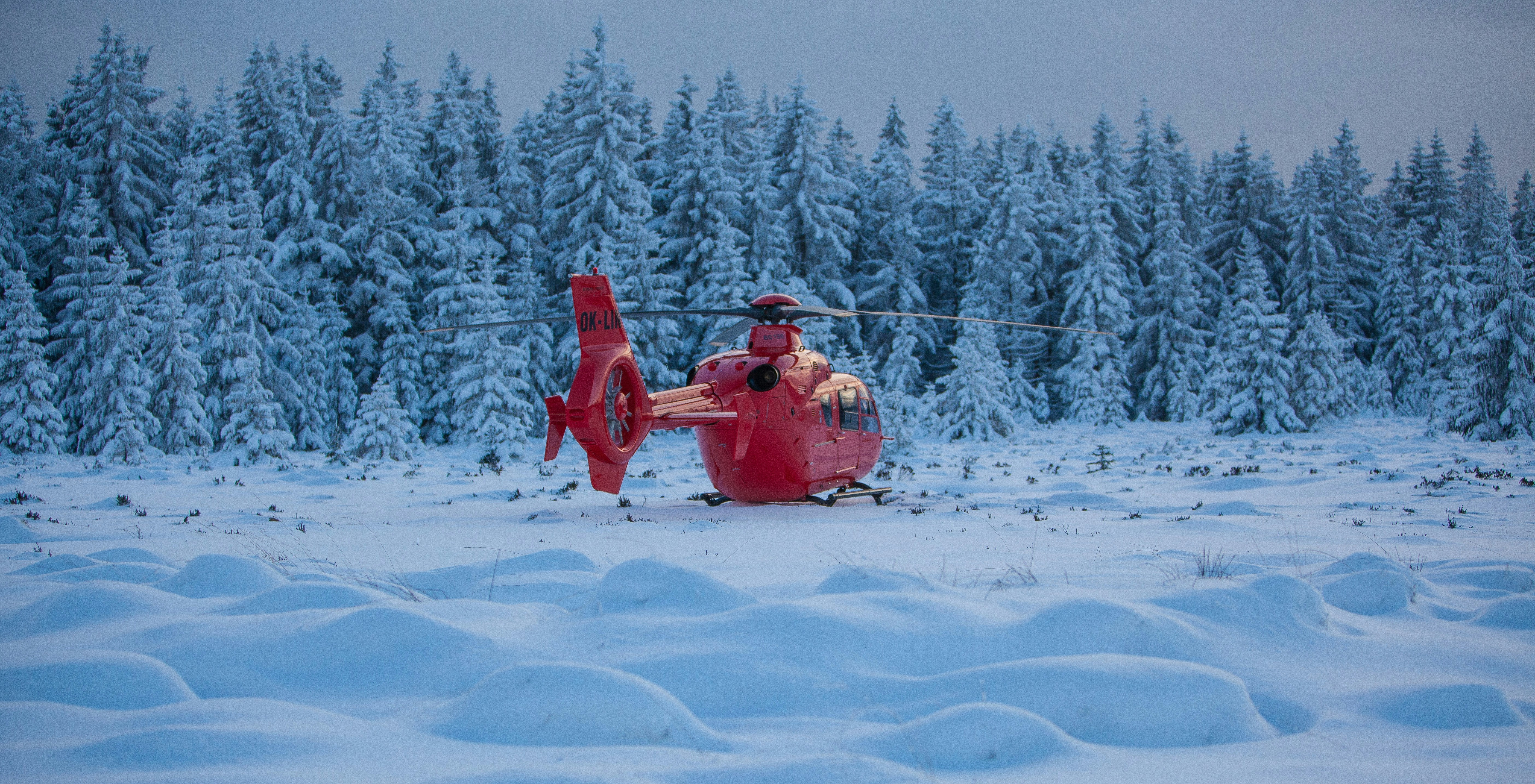 a couple of people sitting on top of a snow covered field