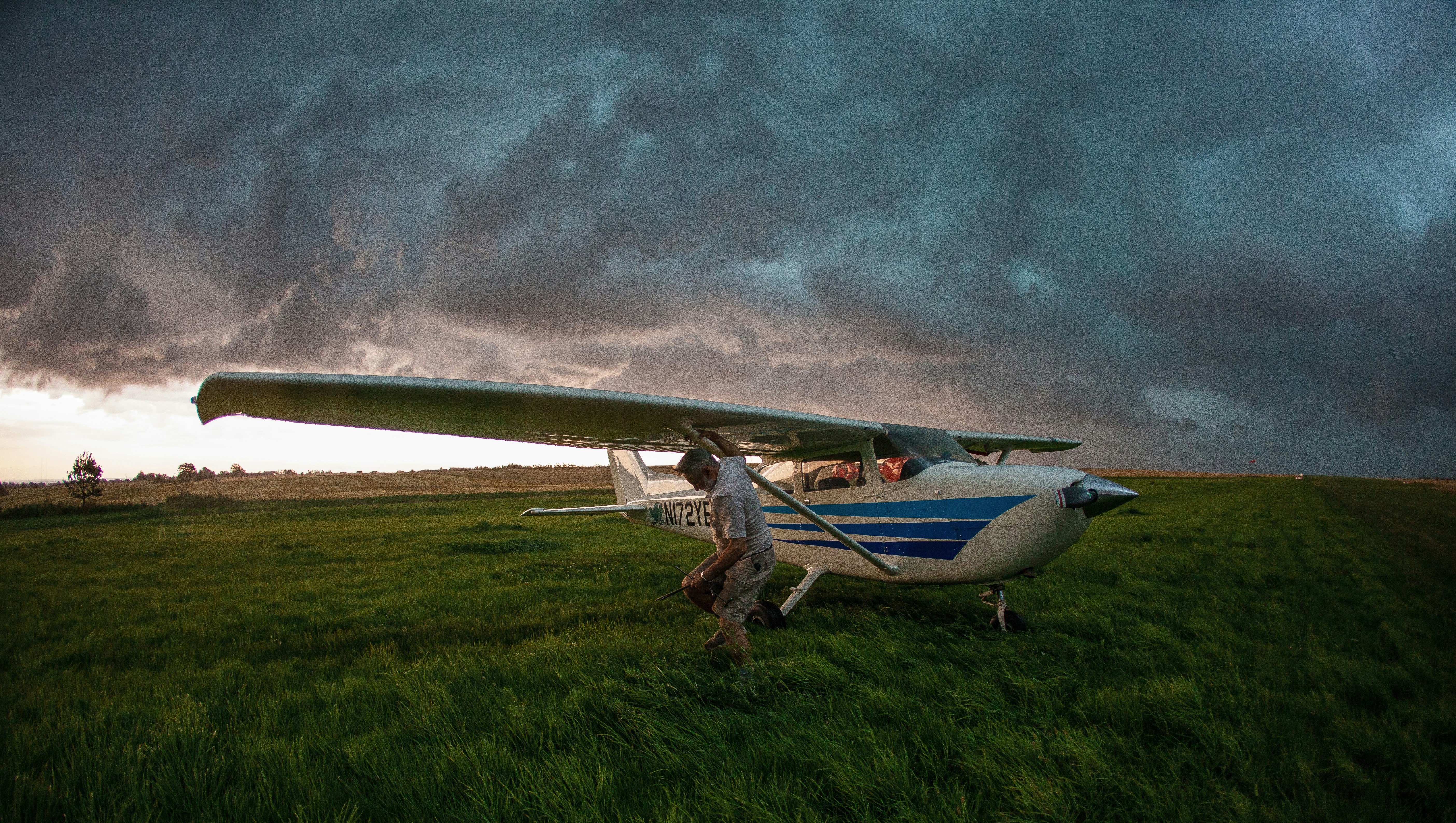 a small airplane sitting on top of a lush green field, 