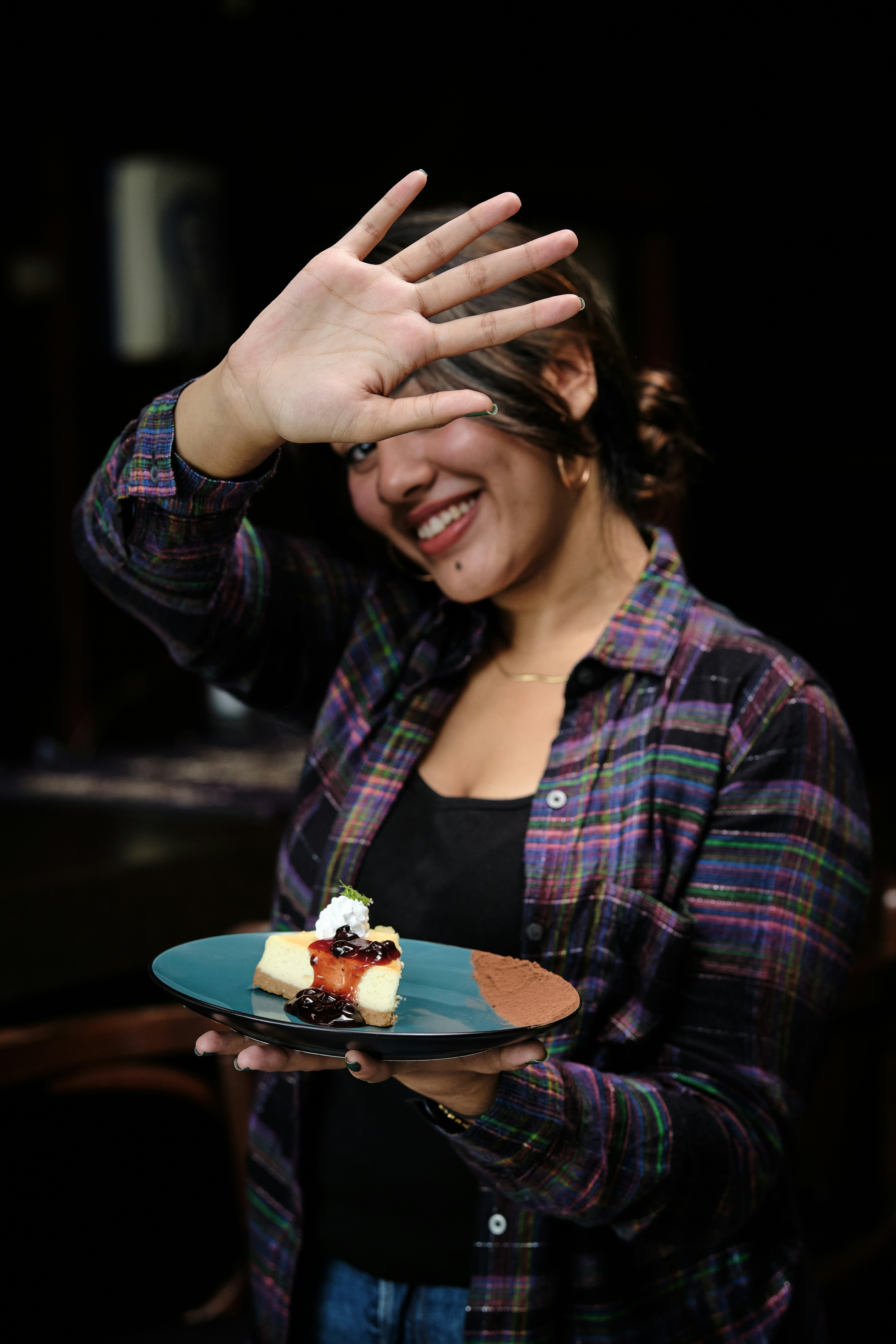 a woman holding a plate with a piece of cake on it