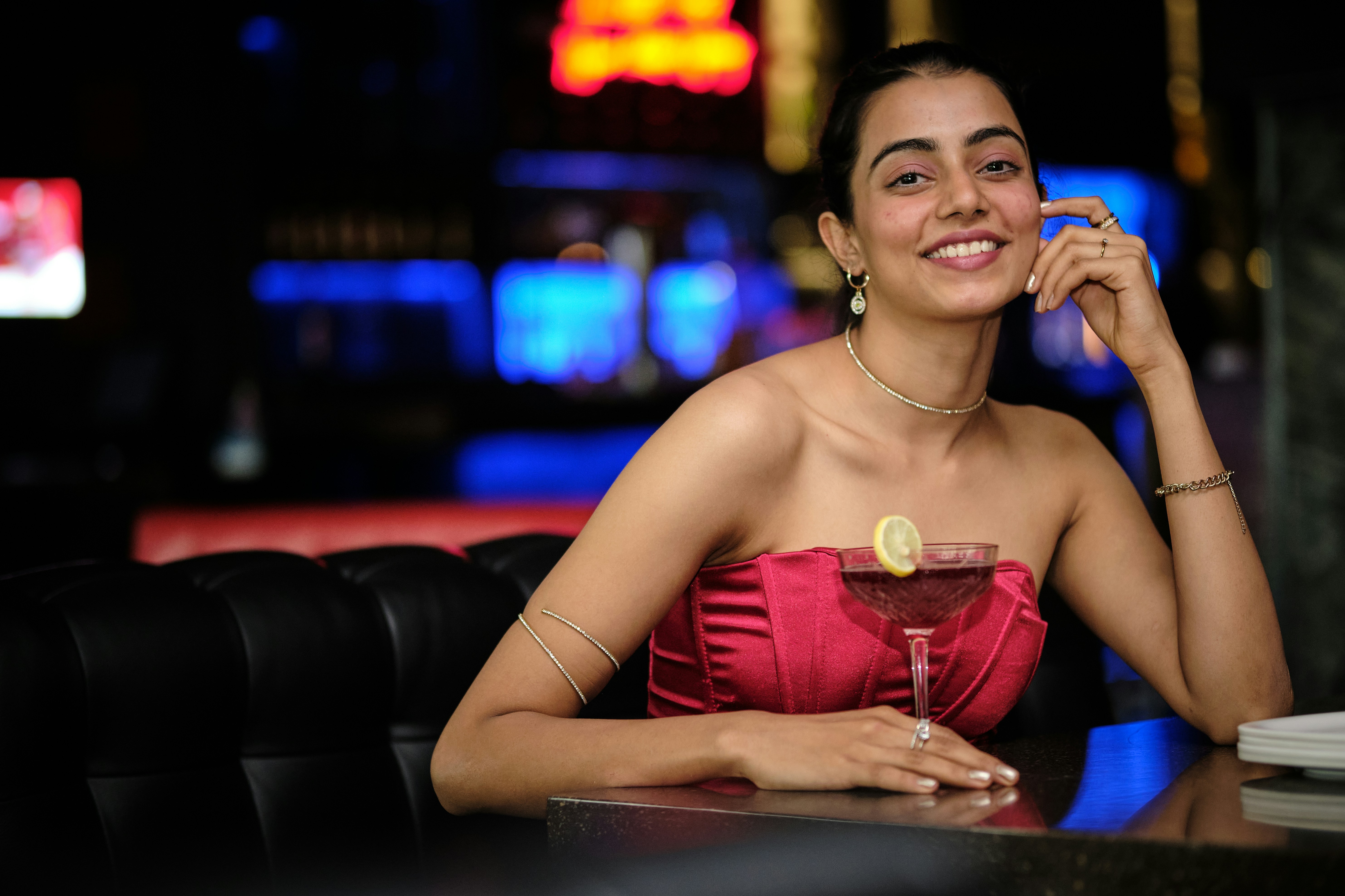 a woman sitting at a table with a drink