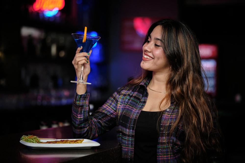 a woman holding a martini glass up to her face