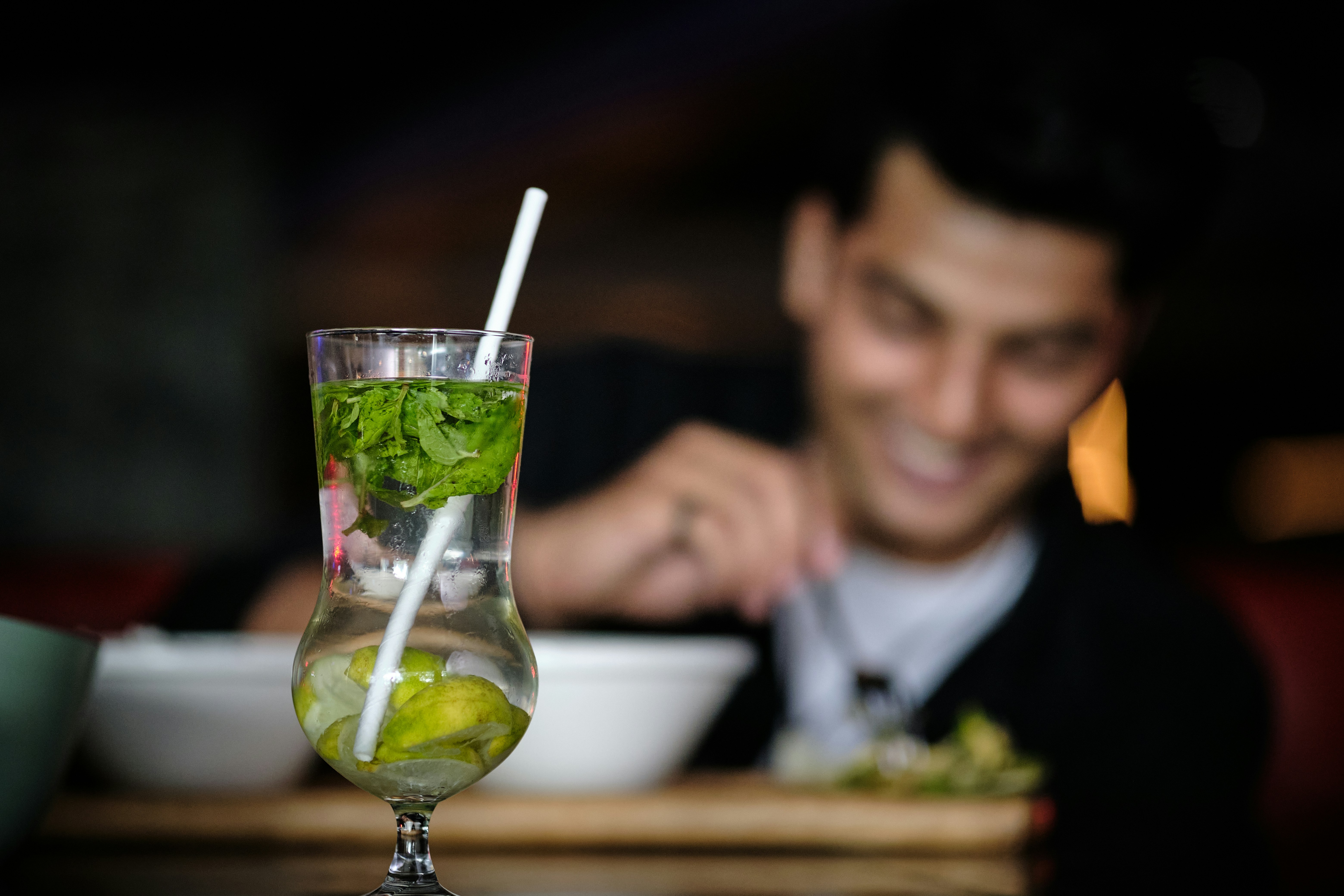 a man sitting at a table with a bowl of food and a drink