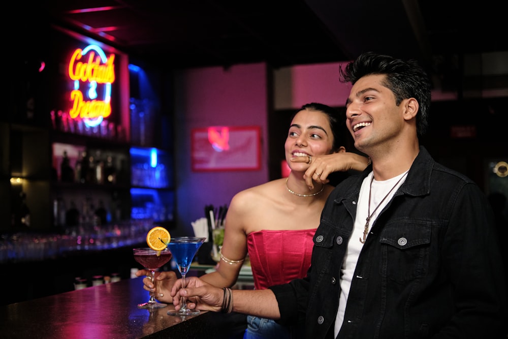 a man standing next to a woman at a bar