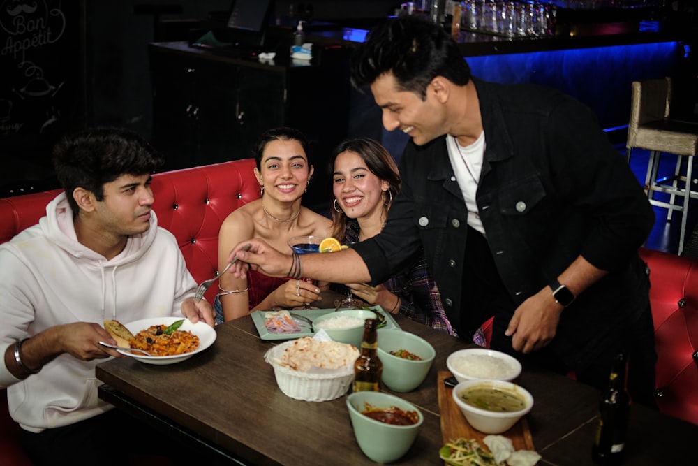 a group of people sitting around a table eating food